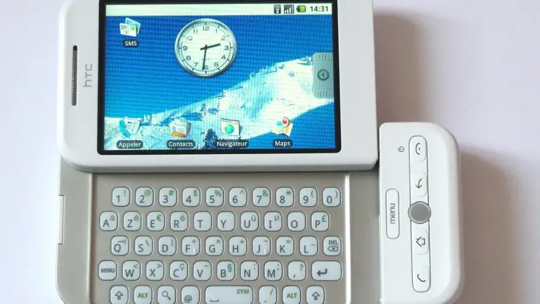 HTC Dream bianco con schermo Android acceso e tastiera AZERTY aperta.