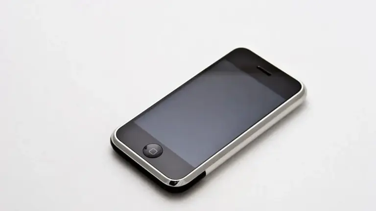 Primo iPhone da 8 GB appoggiato in diagonale su una superficie chiara.
