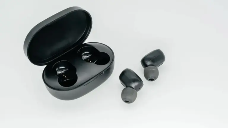 Auricolari wireless neri accanto alla custodia aperta.