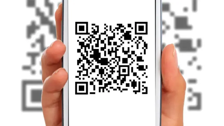 Una mano tiene uno smartphone davanti a un QR Code per eseguirne la scansione.