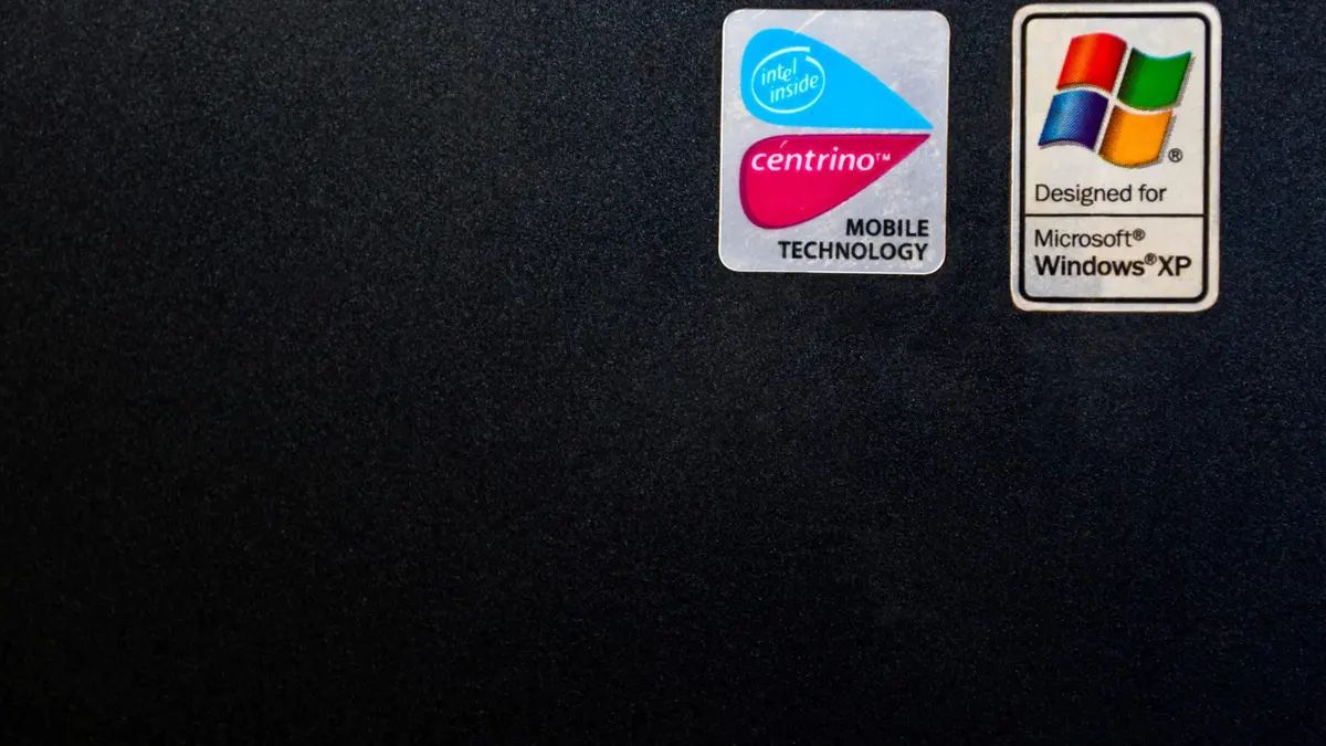 Adesivi Microsoft Windows XP e Intel Centrino sulla superficie nera di un portatile.